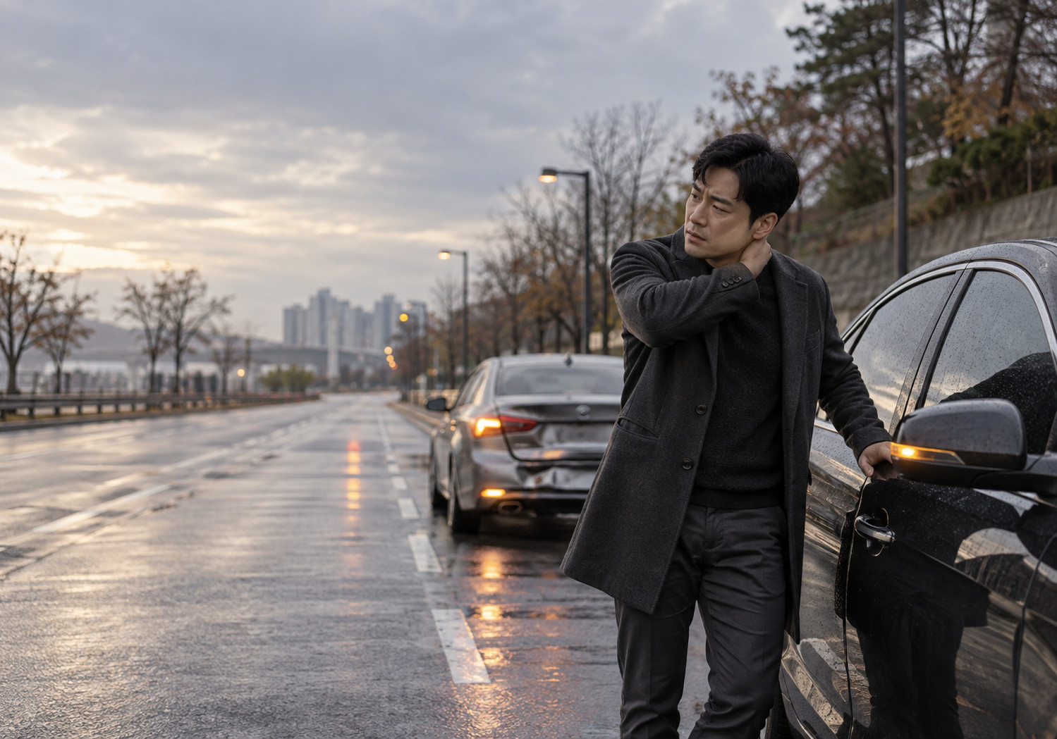안산 교통사고 1인실 – 비 온 도로에서 차 옆에 서서 목을 짚는 남성